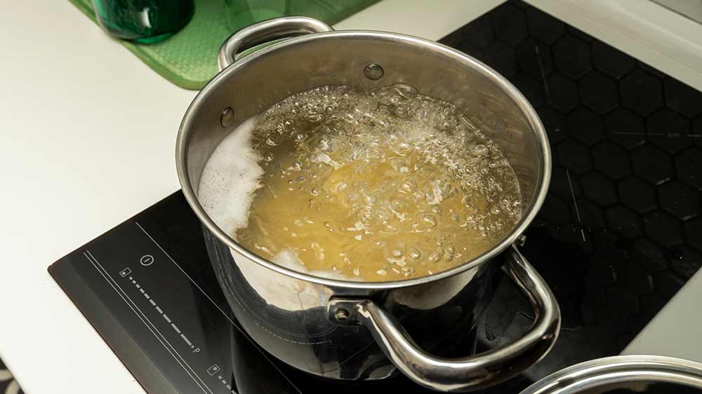 Hrnec s vařící se vodu na sklokeramické desce_02