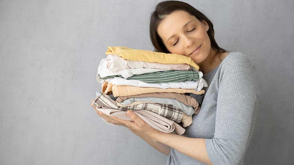 Žena drží hromadu vyžehleného prádla_04