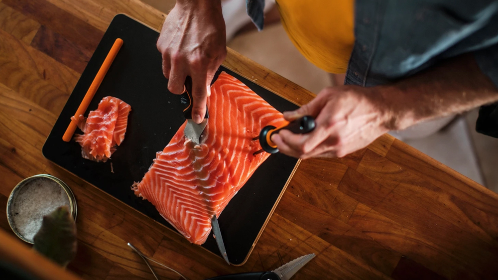 Muž filetuj&iacute;c&iacute; lososa s filetovac&iacute;m nožem Fiskars Functional Form 22 cm_02