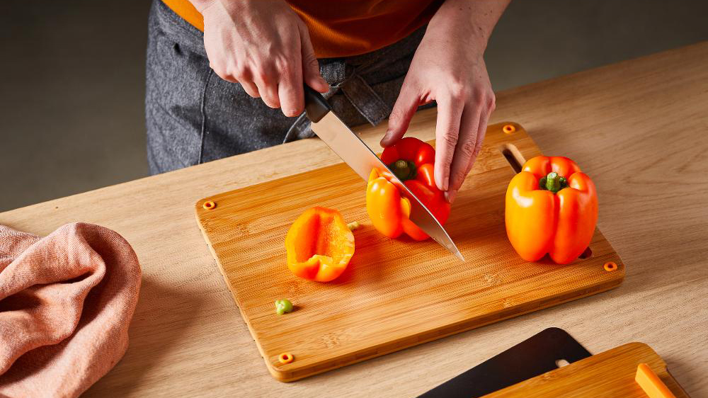 Muž krájí papriku na prkénku Fiskars _03
