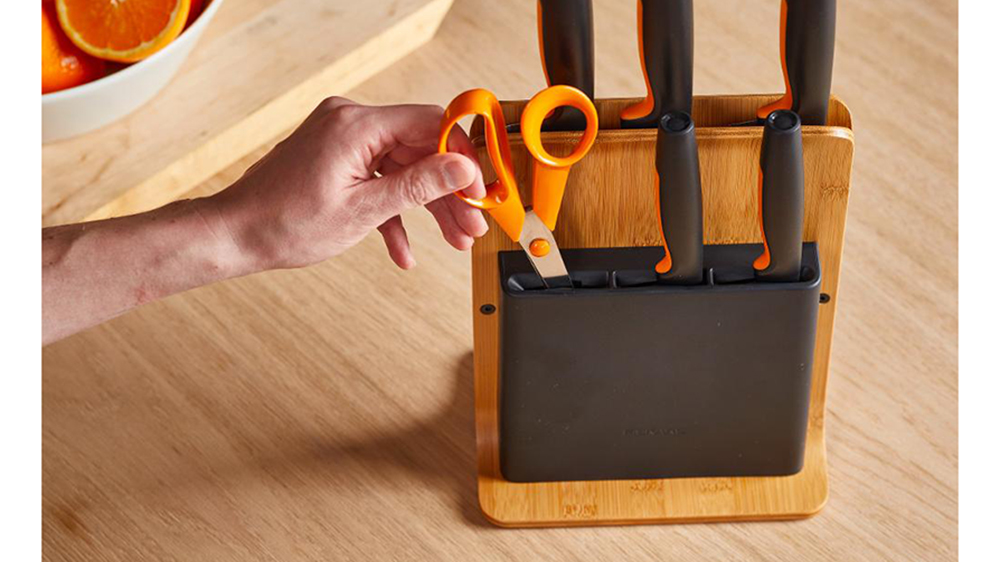 Člověk vytahující nůžky s bambusového bloku s pěti noži Fiskars Functional Form 1057552_02