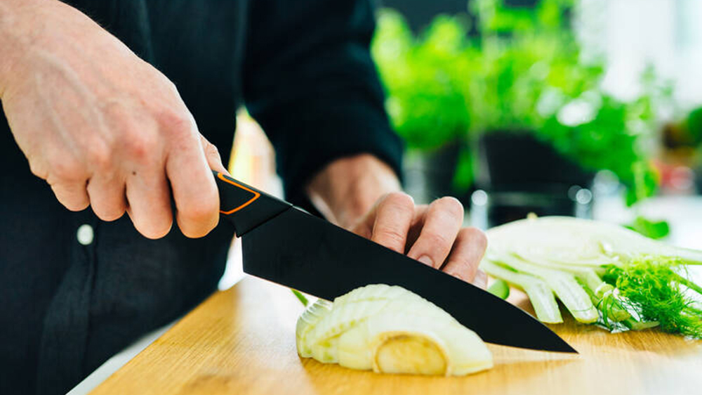 Muž krájející zeleninu kuchařským nožem FISKARS 15 cm _02