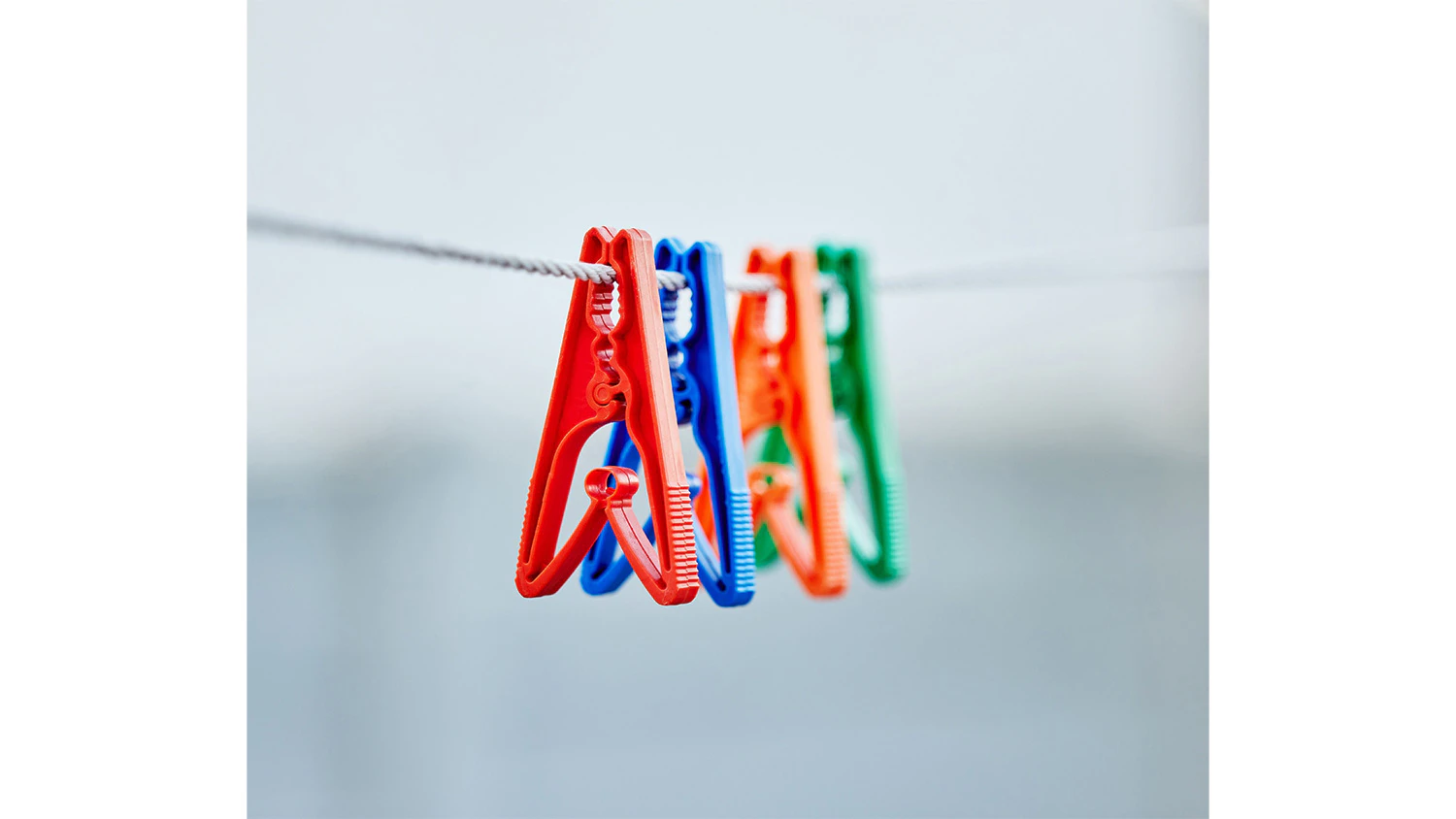 Červen&yacute;, modr&yacute;, oranžov&yacute; a zelen&yacute; kol&iacute;ček pově&scaron;en&yacute; na tkan&eacute; &scaron;ňůře