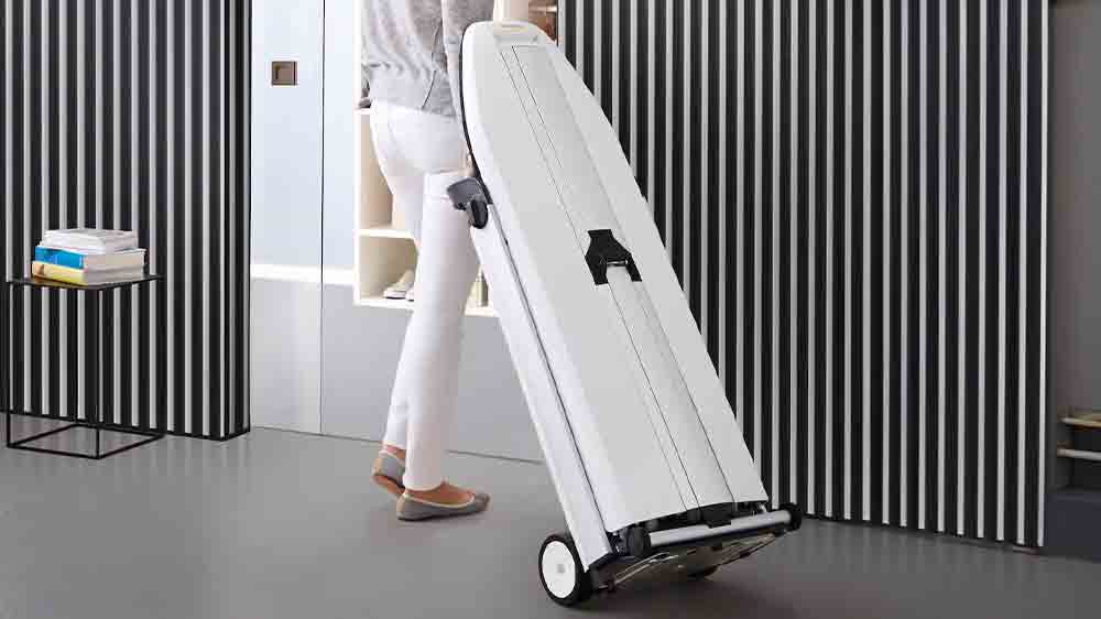 Žena přemisťuje složen&yacute; parn&iacute; žehlic&iacute; syst&eacute;m Miele B 4847 FashionMaster_06