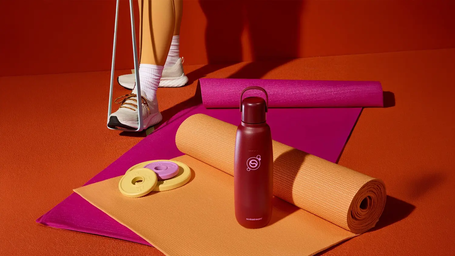 Dievča d&aacute;vaj&uacute;ce si fľa&scaron;u SodaStream Fizz&Go COOL do batoha