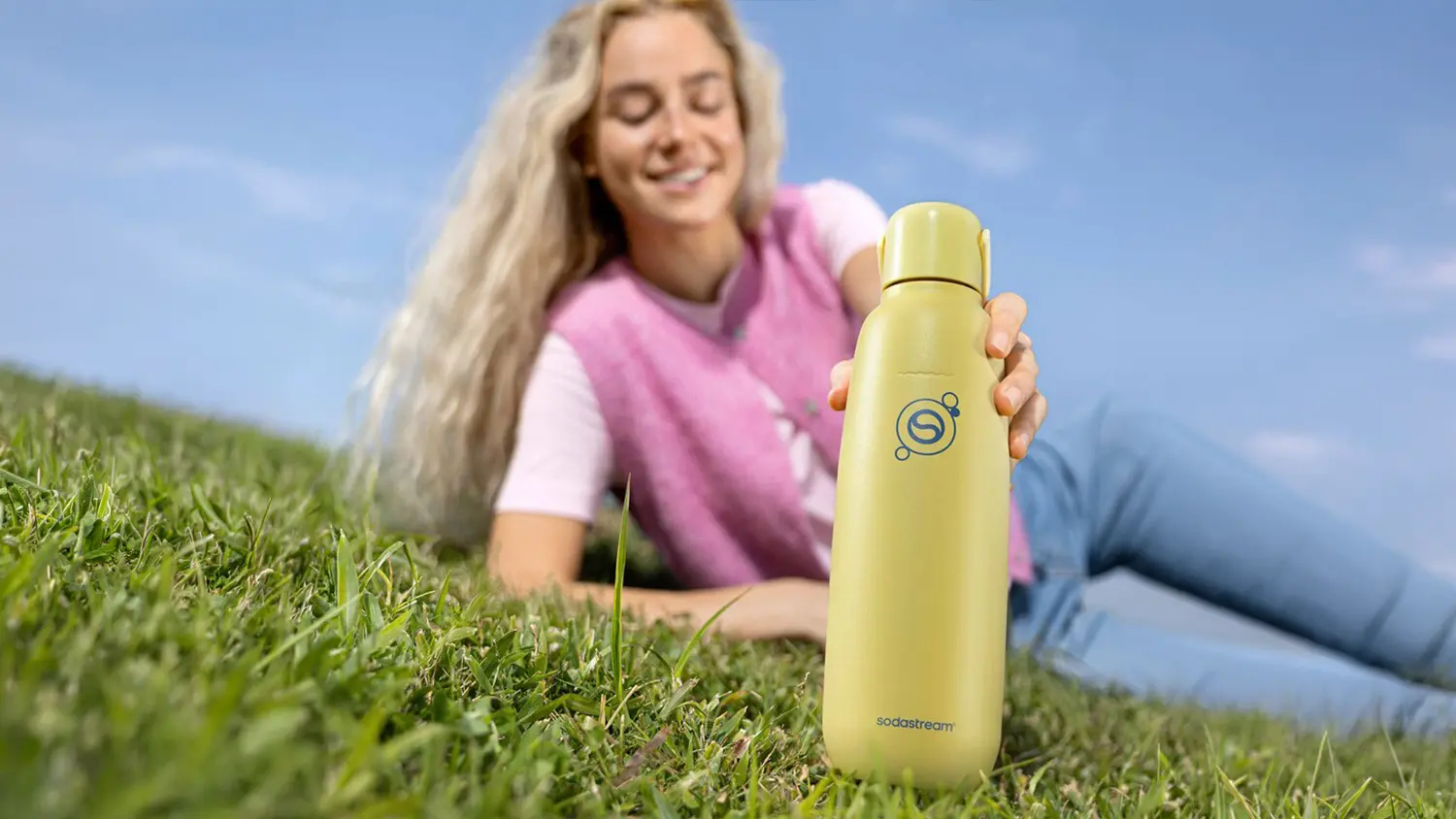 Dievča d&aacute;vaj&uacute;ce si fľa&scaron;u SodaStream Fizz&Go COOL do batoha