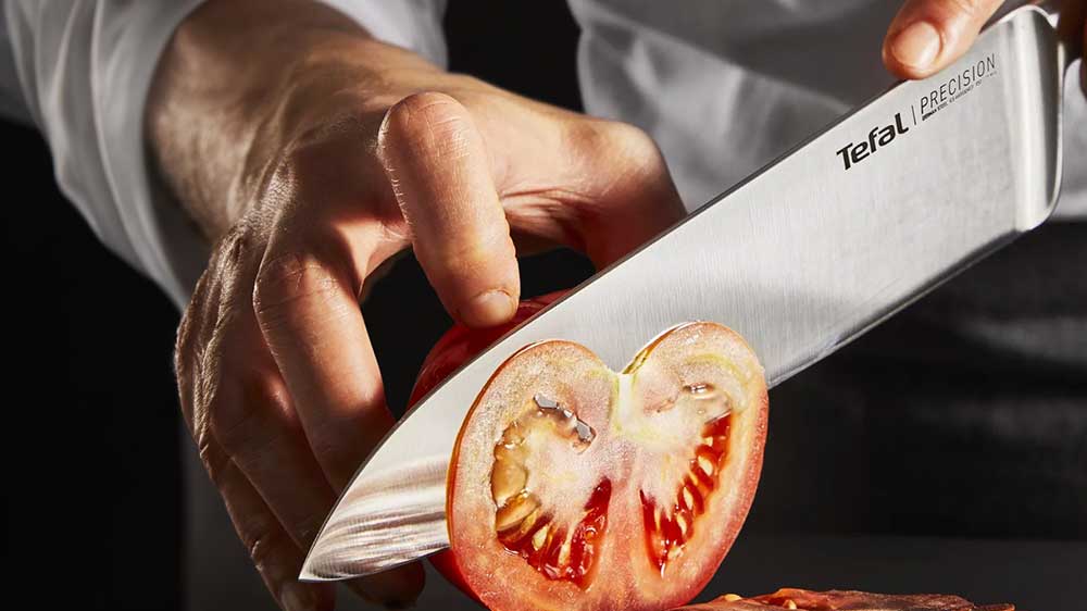 Kuchař krájí rajče pomocí kuchyňského nože chef Tefal Precision K2890224_03