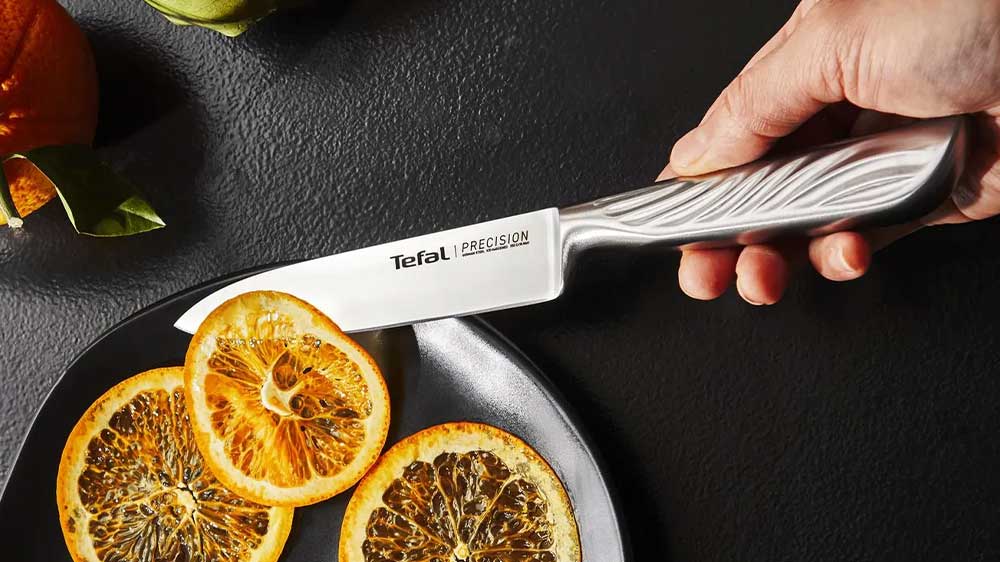 Nakrájený pomeranč pomocí kuchyňského nože Tefal Precision K2890524 na talíři_03