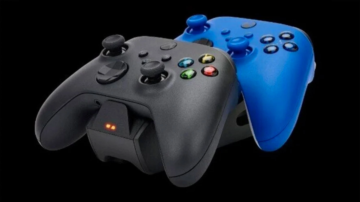 Černý a modrý ovladač pro Xbox v černé dobíjecí stanici s rozsvíceným LED indikátorem nabíjení.