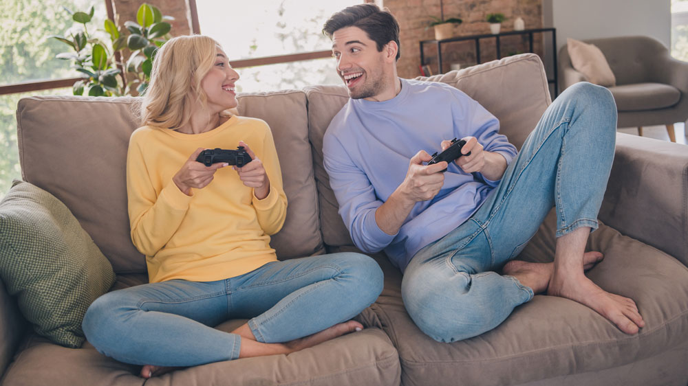 Pár sedí na sedačke a hrá hry na playstation_04