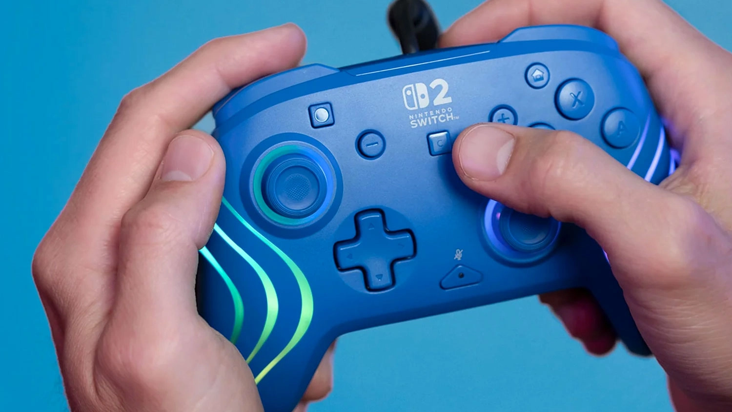 Ruky držia gamepad Turtle Beach Afterglow Wave Wired NS2 Blue