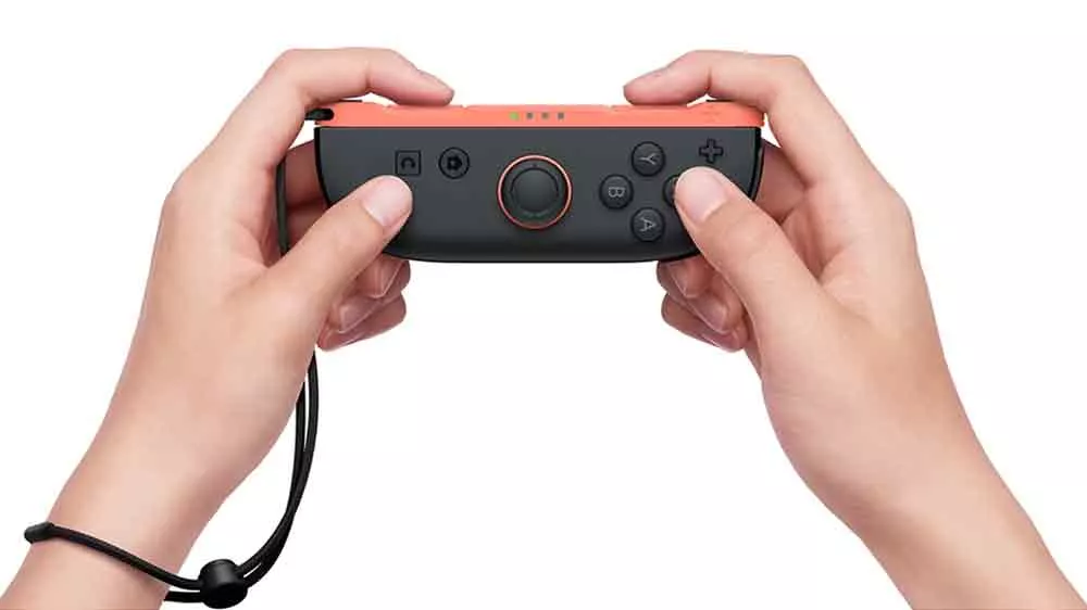 Ruky človeka držiaceho herný ovládač Nintendo Joy-Con 2 (R) Light Red_02