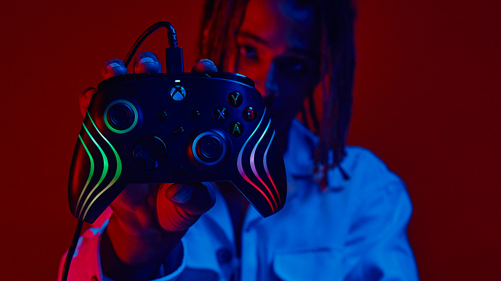 Muž držící herní ovladač PDP Afterglow Wave, drátový_02