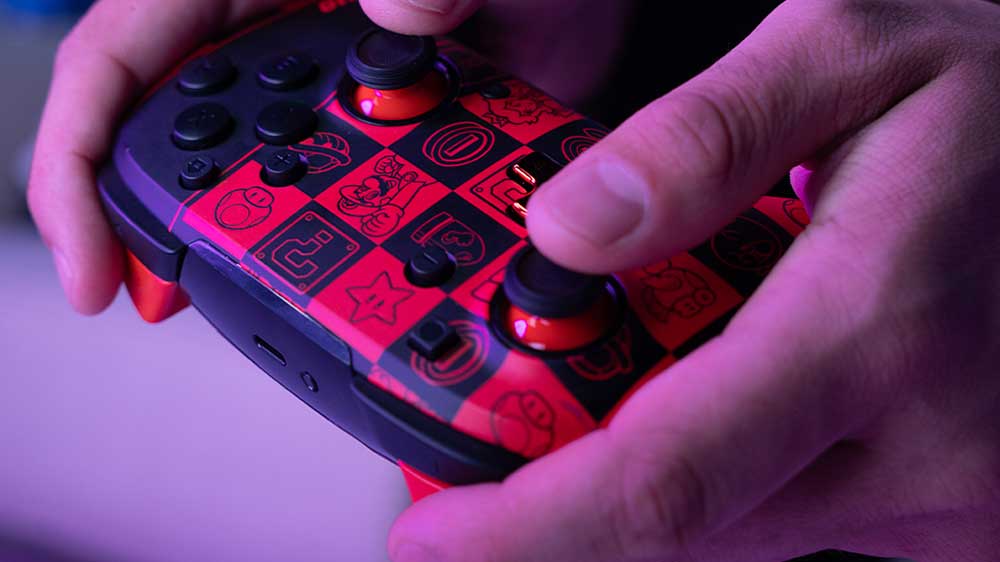 Mužské ruce drží bezdrátový gamepad PDP Rematch Glow pro Nintendo Switch, Super Icon_02