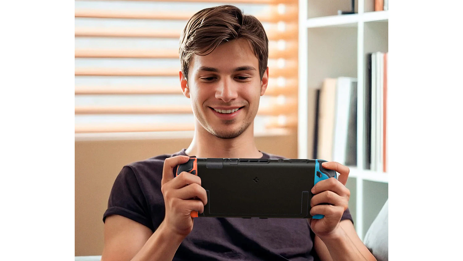 Usmívající se mladý muž drží v ruce Nintendo Switch 2 v pouzdru Spigen Nano Pop Special Edition a hraje hru
