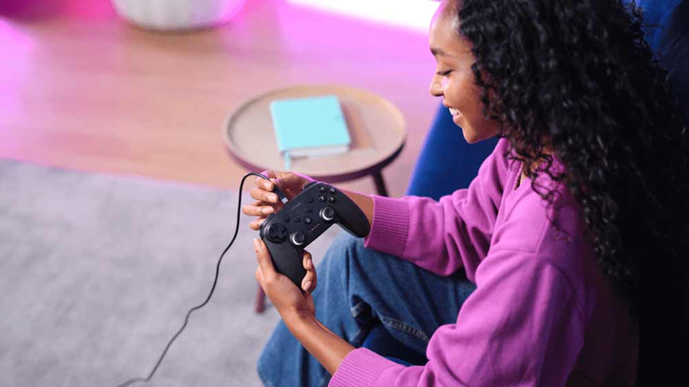 Žena zapojuje kábel do gamepadu Trust GXT542 MUTA Black_02