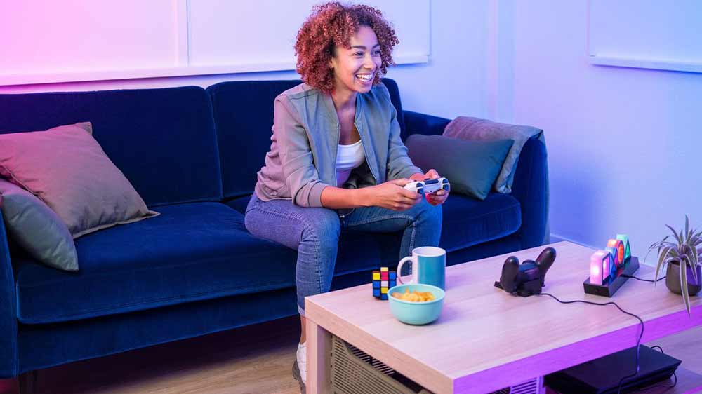 Žena hrající na konzoli s nabíjecí stanicí Trust GXT 235 na stole_02