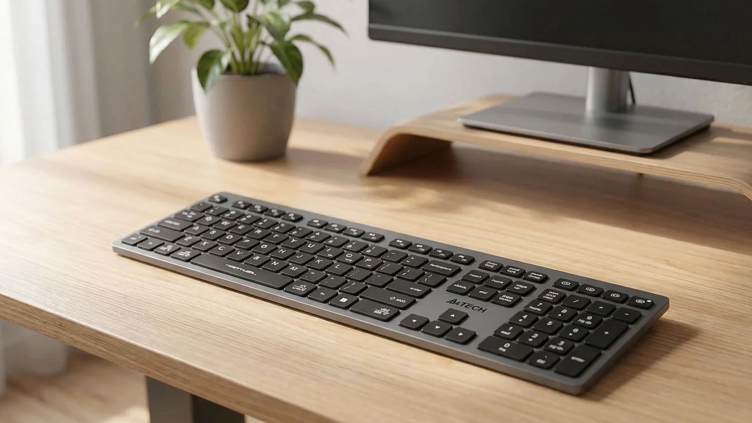 Bezdrôtová klávesnica A4TECH FSTYLER FBX50C s nízkoprofilovými klávesmi položená na drevenom pracovnom stole.