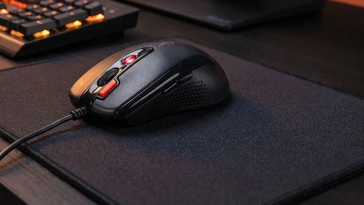 Čierna herná myš A4TECH X-710BK položená na čiernej podložke na stole.