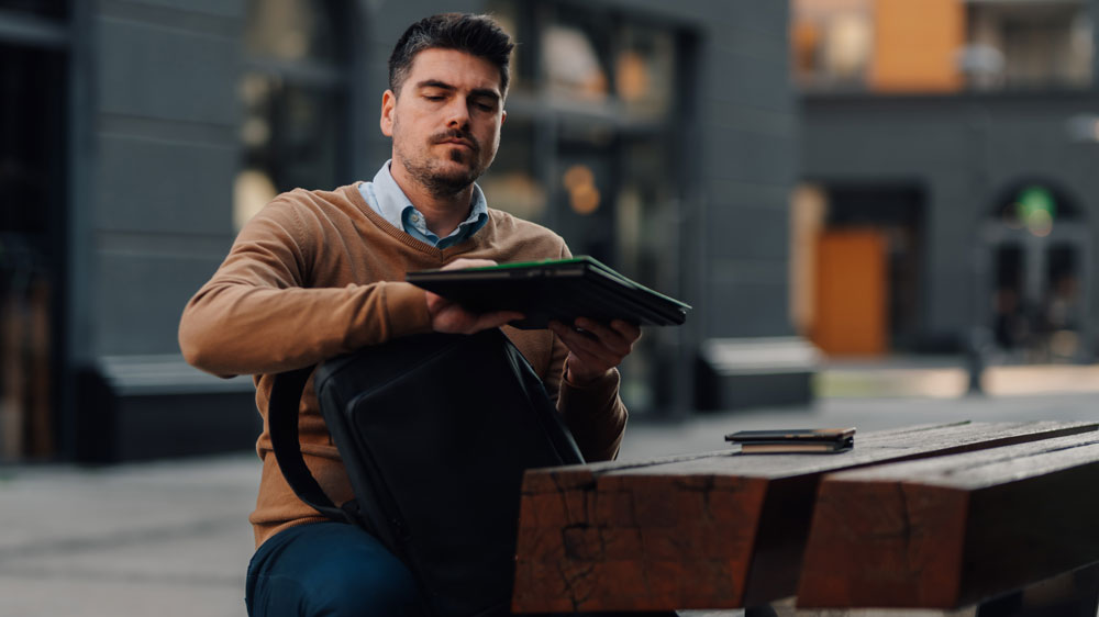 Muž dává notebook do batohu_02