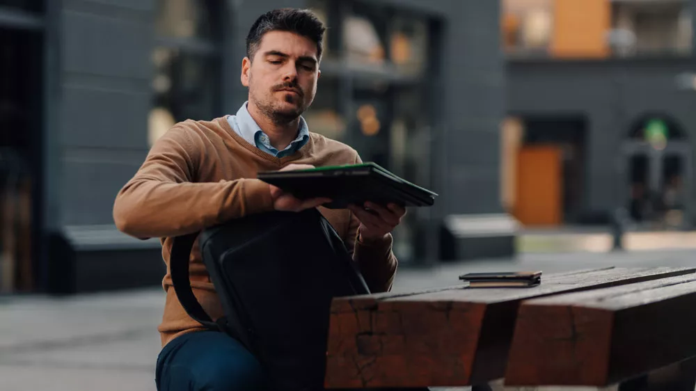 Muž dává notebook do batohu_02