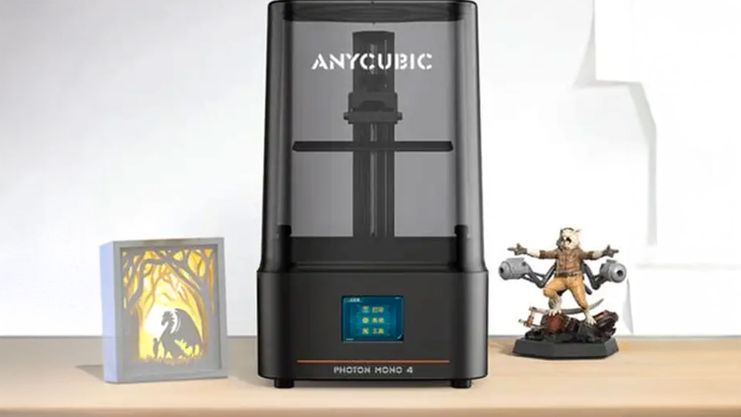 Čierna 3D tlačiareň Anycubic Photon Mono 4 na stole doplnená vytlačenou figúrkou a dekoratívnym rámčekom.