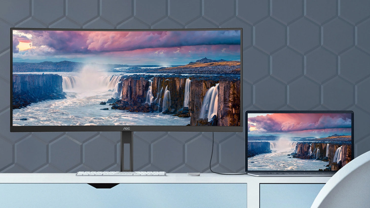 Monitor AOC U34V5C/BK monitor s notebookom na stole.