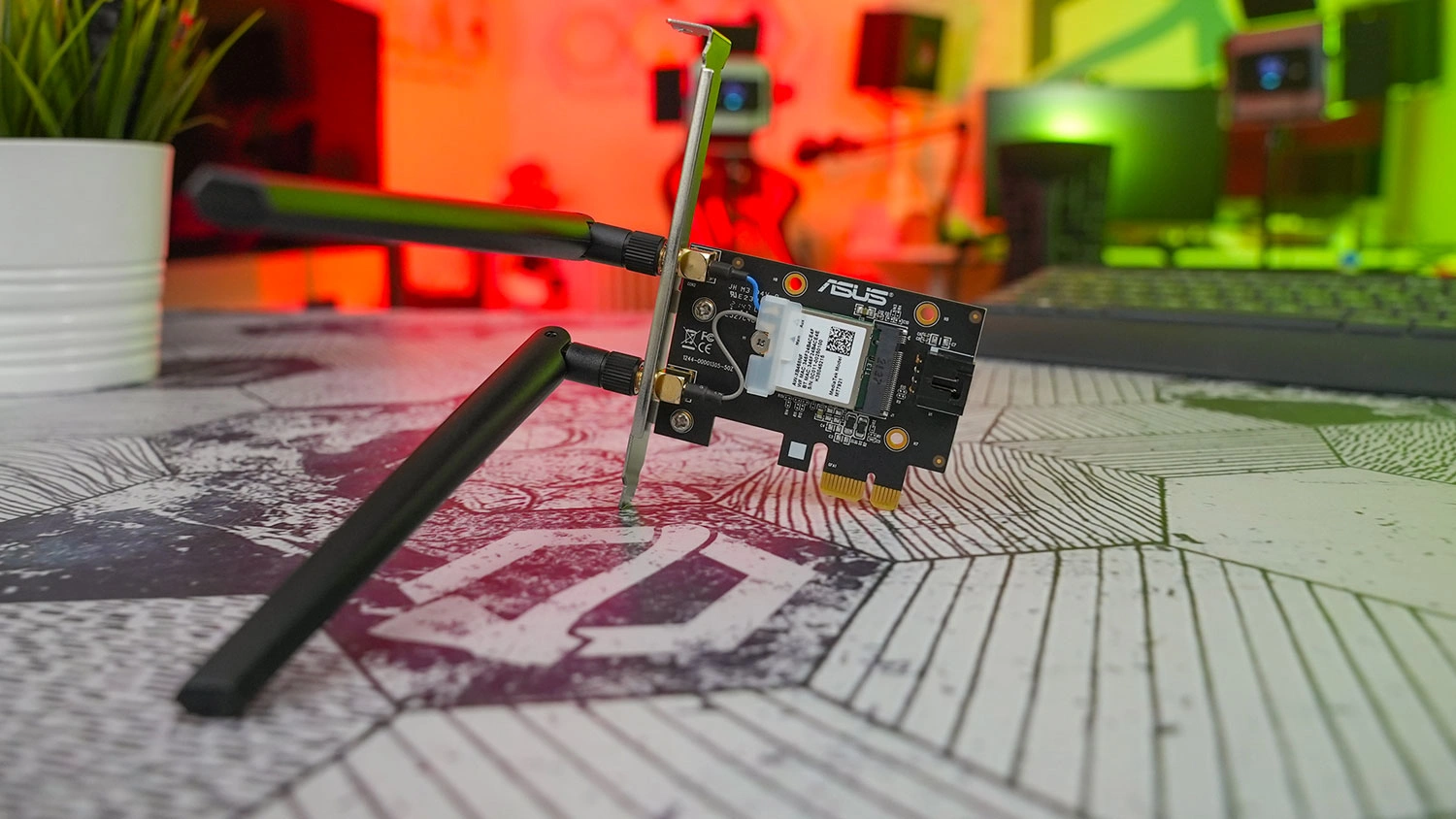 PCI-e adapt&eacute;r Asus PCE-AX1800 položen&yacute; na koberci