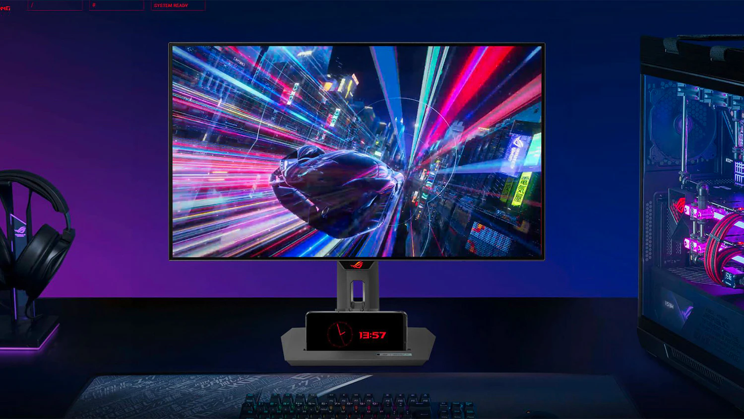 ASUS ROG Strix OLED XG27AQDMG na stole s telef&oacute;nom v stojančeku