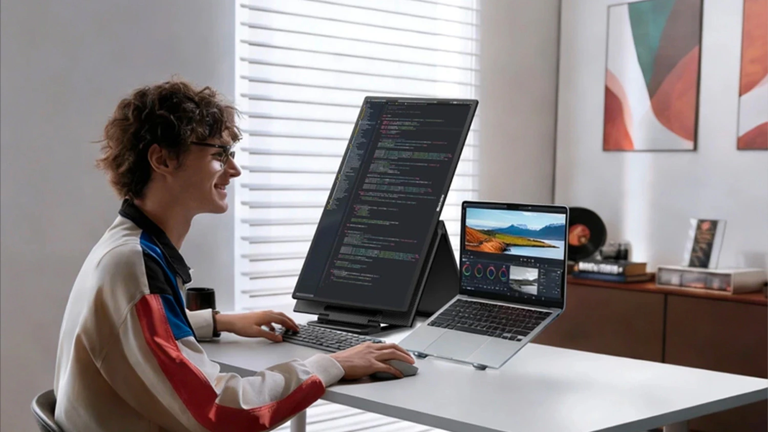 Muž pracuje na notebooku s připojeným monitorem Blackview