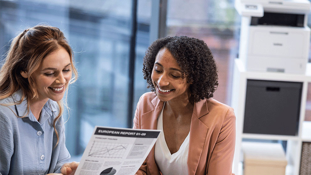 Ženy prohlížející si vytištěnou stránku_03