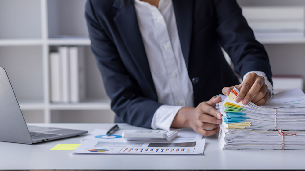 Člověk prohrabující se stohem potištěných papírů_04