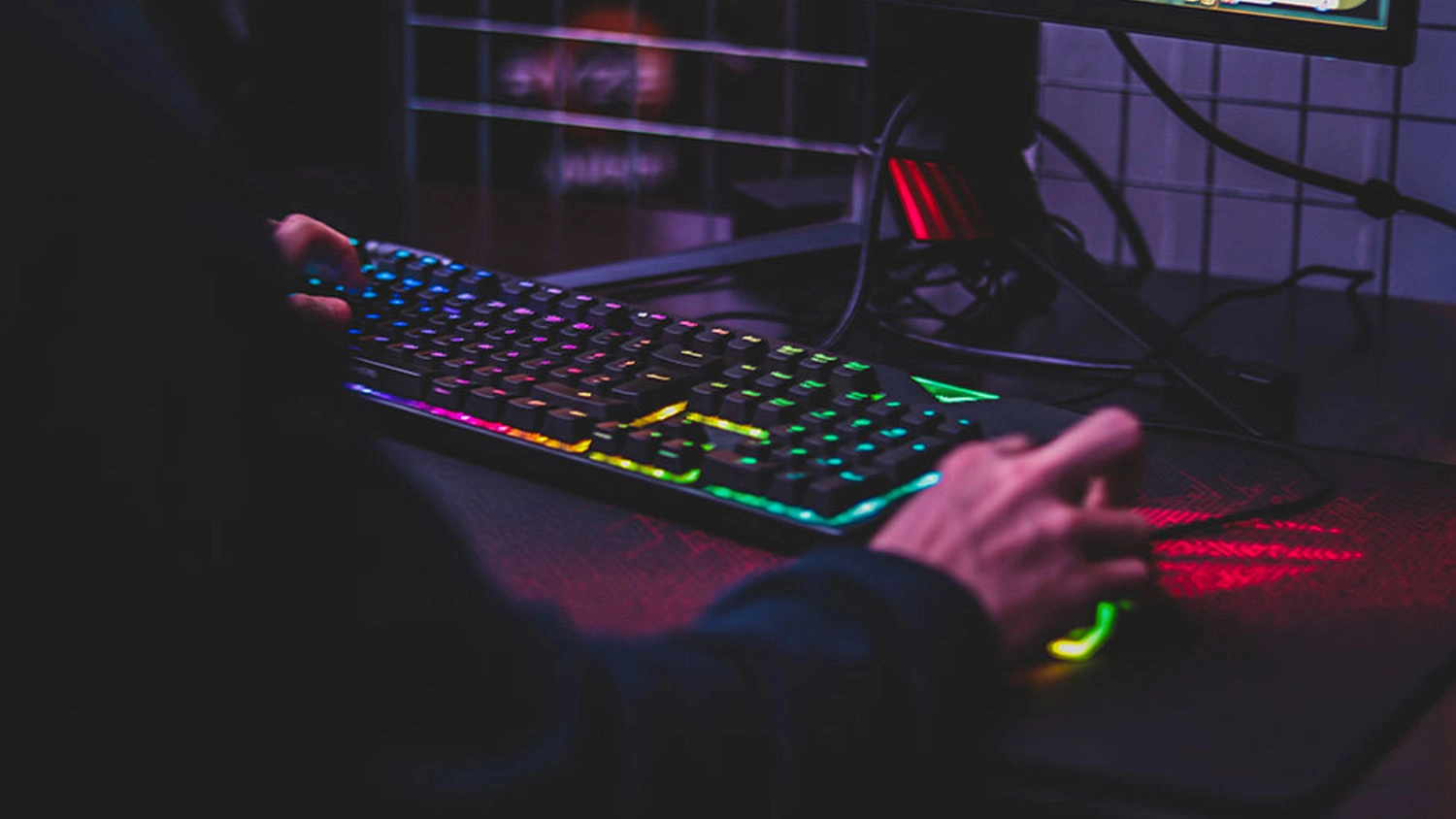 Podsvietená klávesnica na stole pri počítači