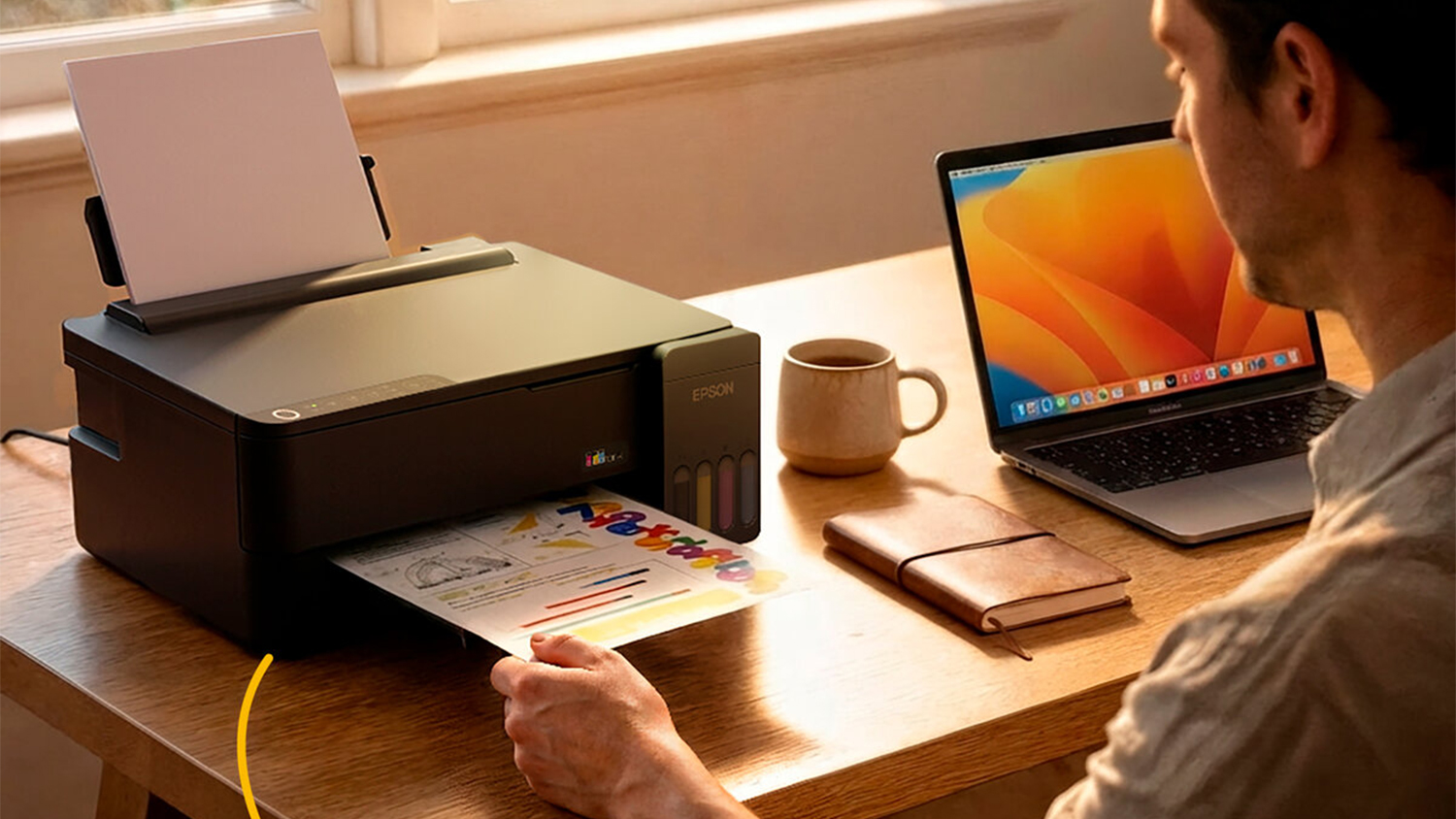 Muž vytahuj&iacute;c&iacute; pap&iacute;r z tisk&aacute;rny Epson EcoTank L1350