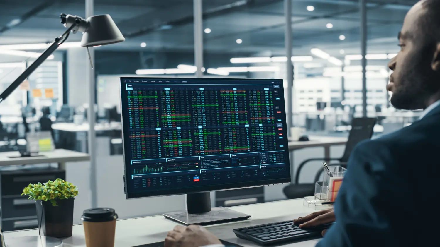 Muž pracuje s grafy na monitoru