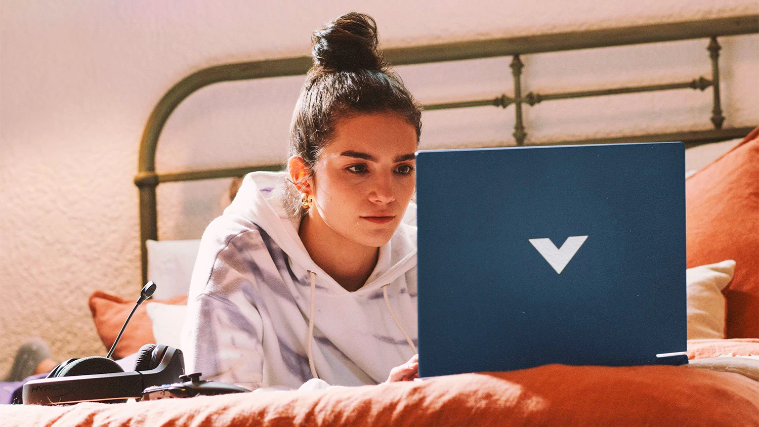 Žena na posteli s notebookem HP Victus