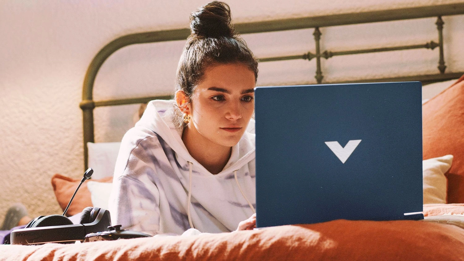 Žena na posteli s notebookem HP Victus