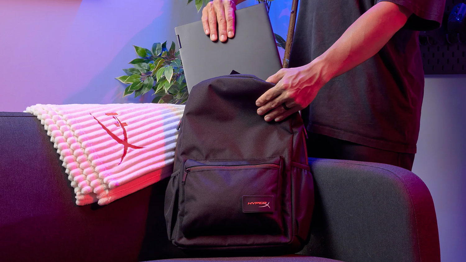 Muž dáva notebook do batohu HyperX Delta