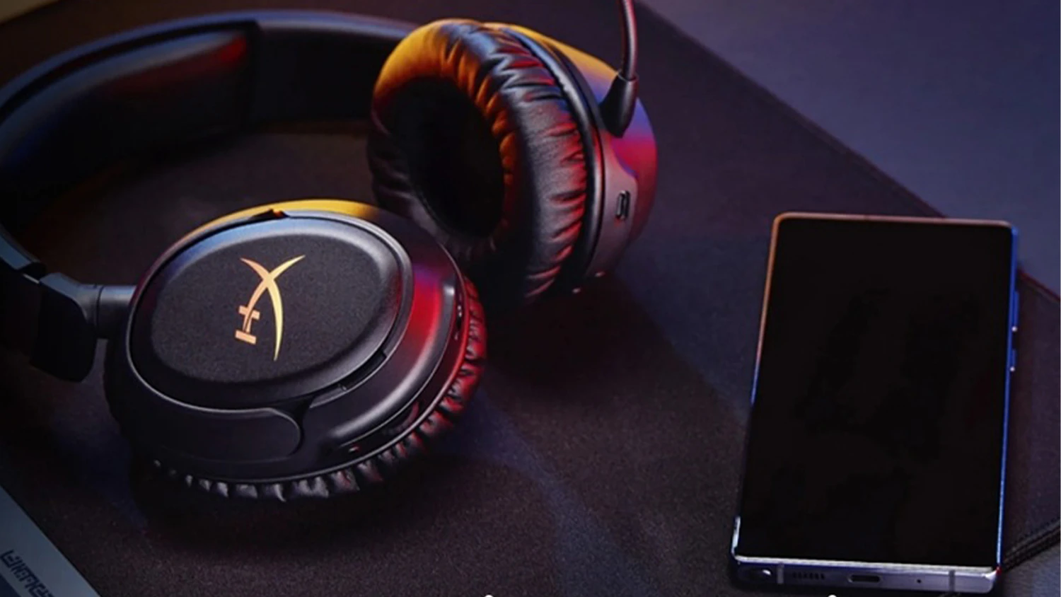 Sluchátka HyperX Cloud Flight 2 Wireless ležící vedle telefonu