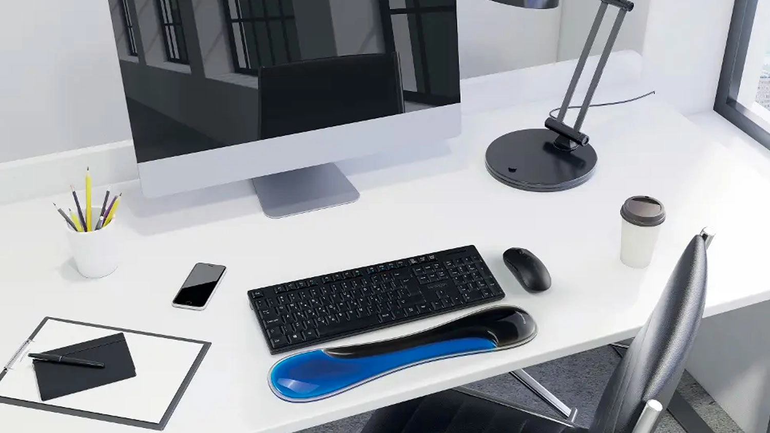 Opěrka z&aacute;pěst&iacute; Kensington Slim Duo před kl&aacute;vesnic&iacute; na pracovn&iacute;m stole u poč&iacute;tače.