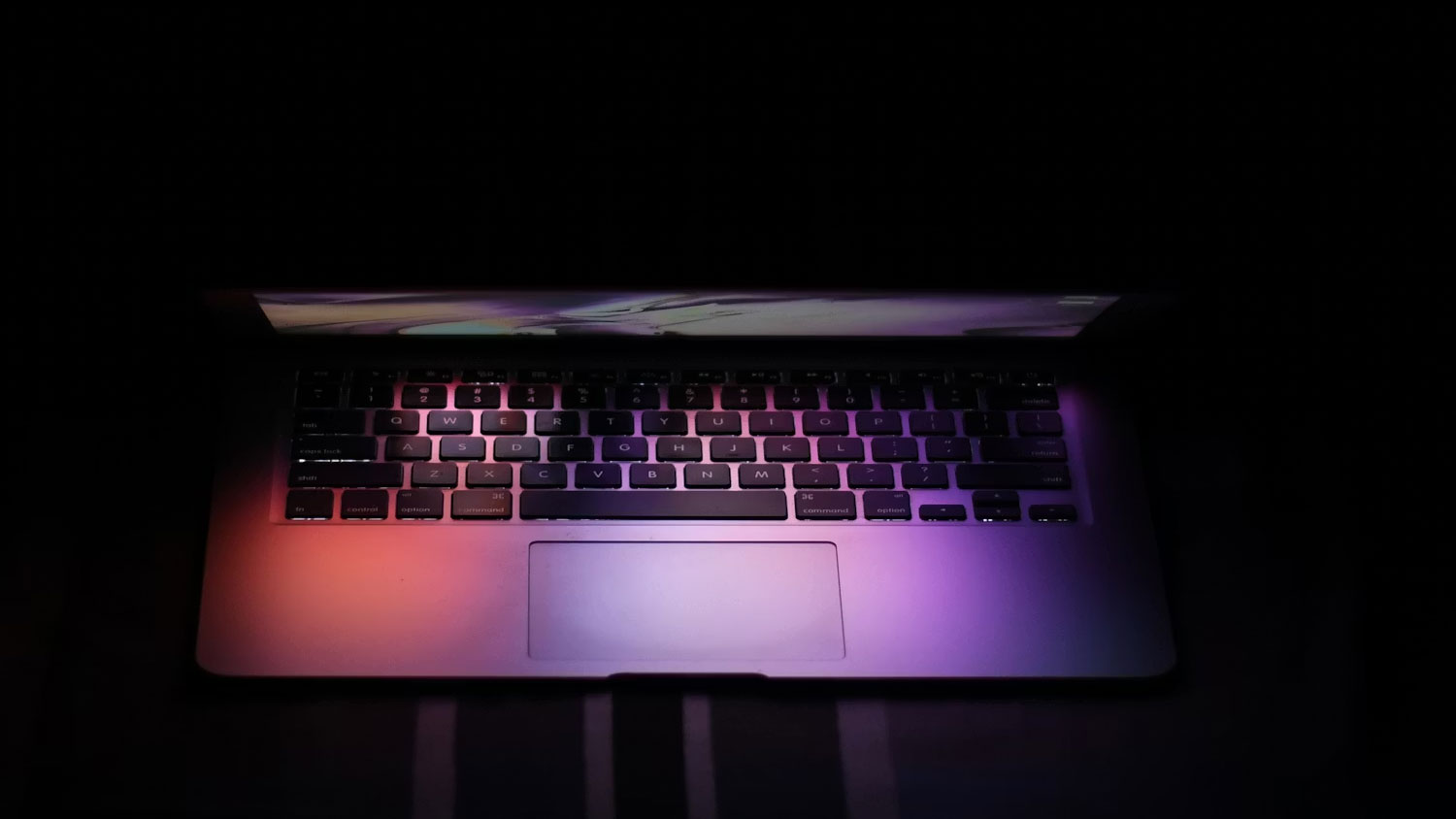 Přivřen&yacute; notebook v tmav&eacute; m&iacute;stnosti