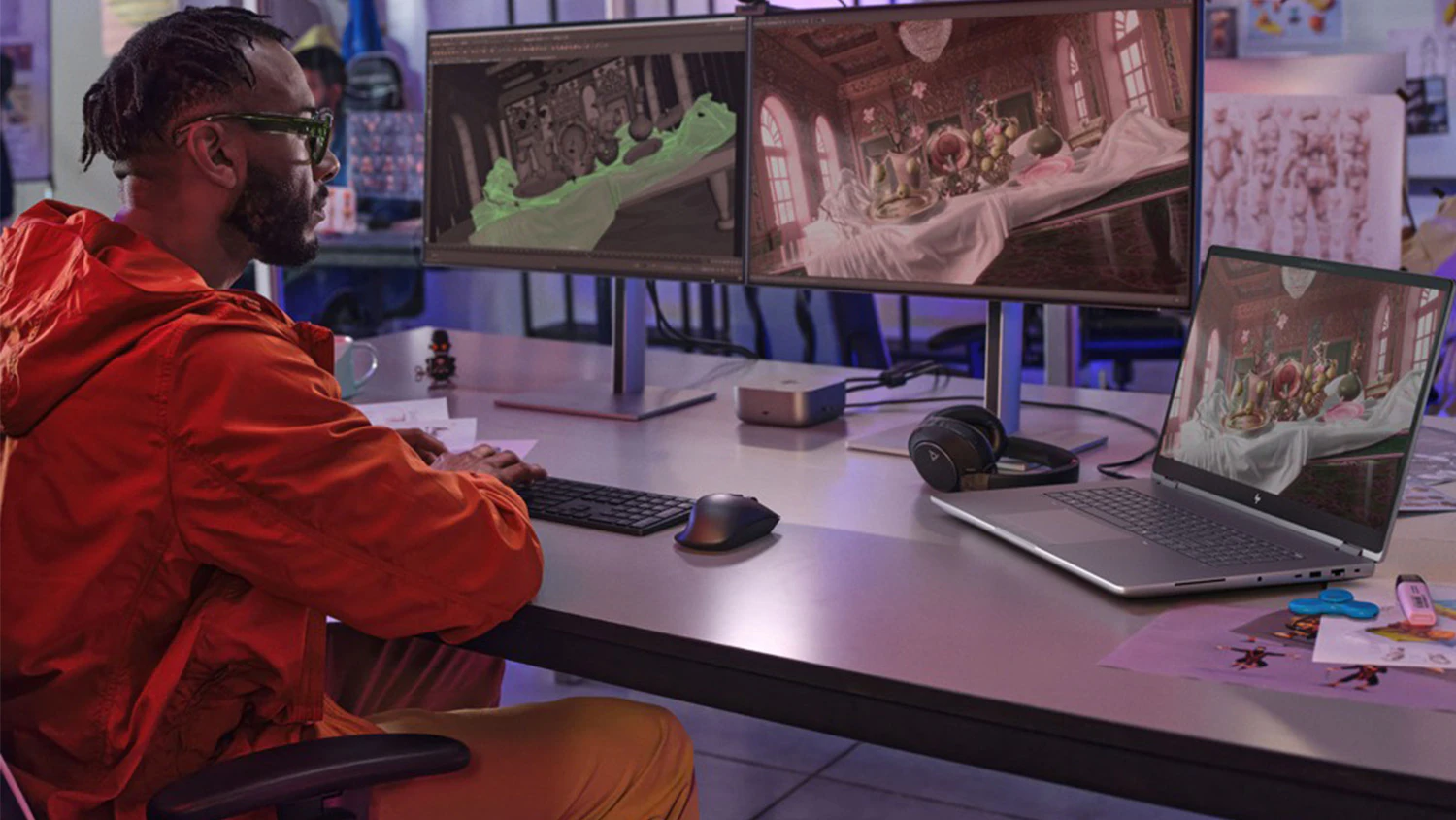 Muž u stolu s monitory a notebookem HP