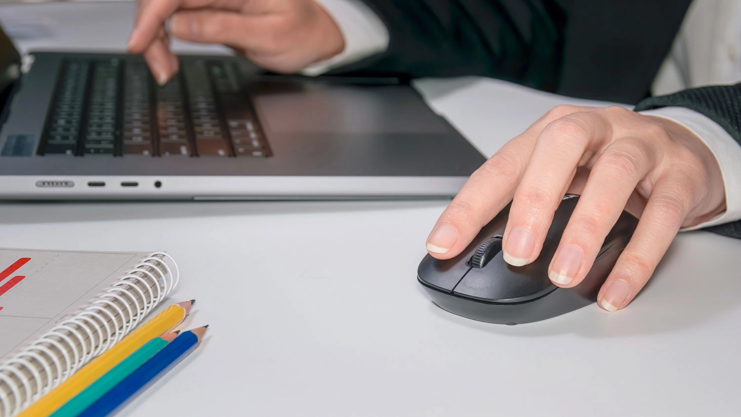 Muž drží v ruke myš pri PC