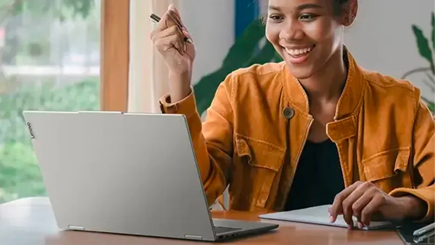 Žena na videohovore pri stole s notebookom