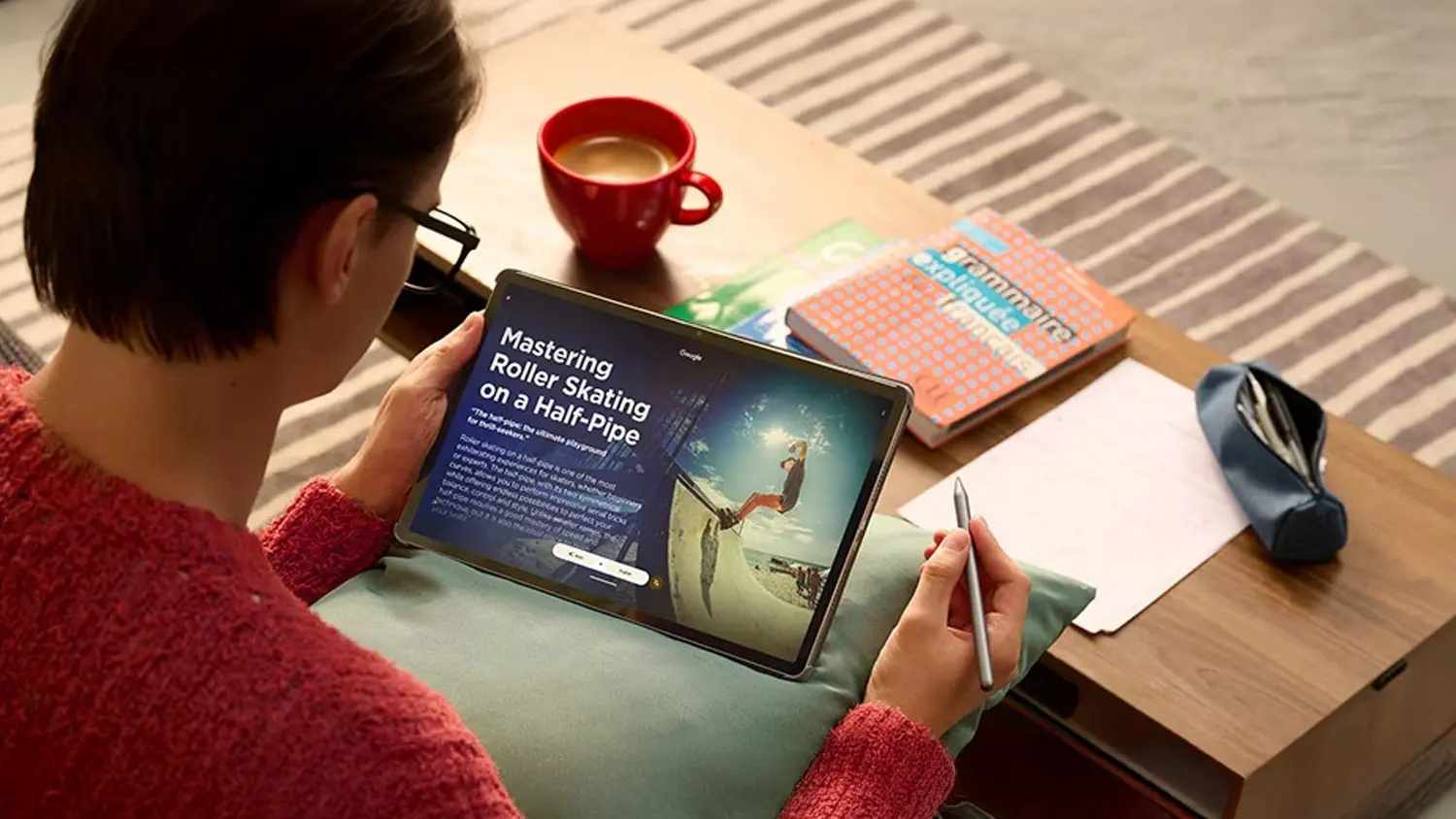 Muž pri stole s papierom a peračn&iacute;kom držiaci tablet Lenovo