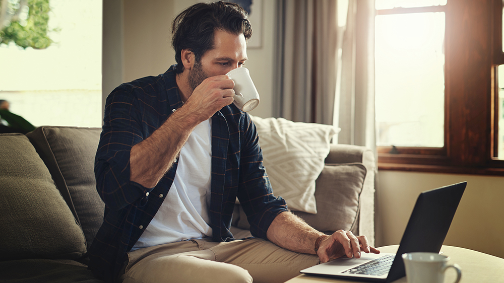 Muž pracující na notebooku v obýváku _04