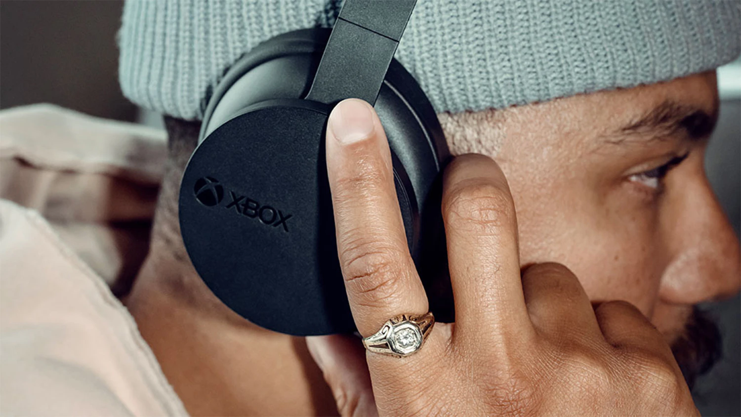Muž upravuj&uacute;ci hlasitosť na sl&uacute;chadl&aacute;ch Xbox