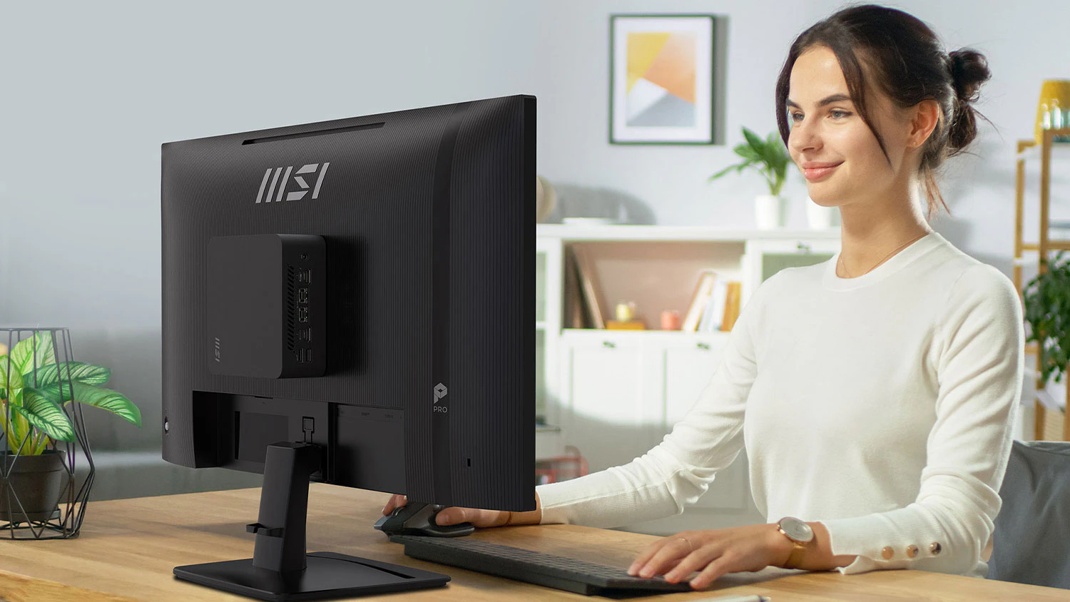 Žena sedící u stolu s monitorem MSI