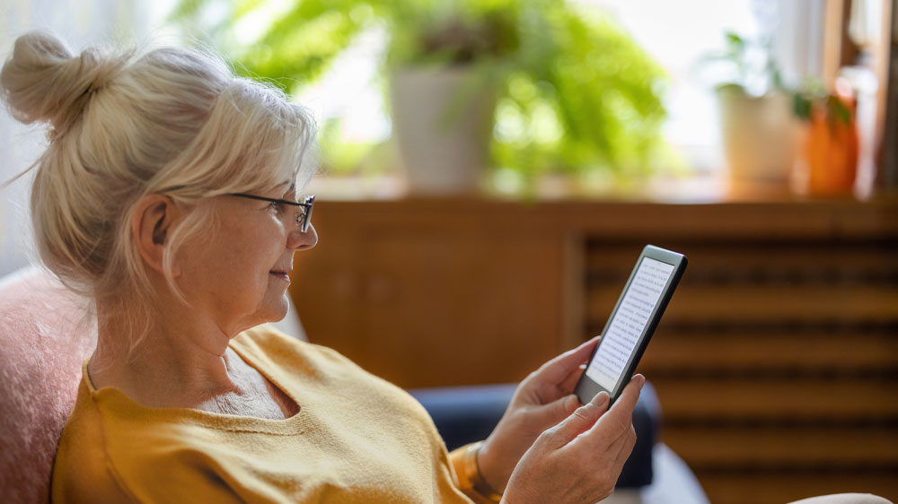 Staršia žena si číta z čítačky kníh_03