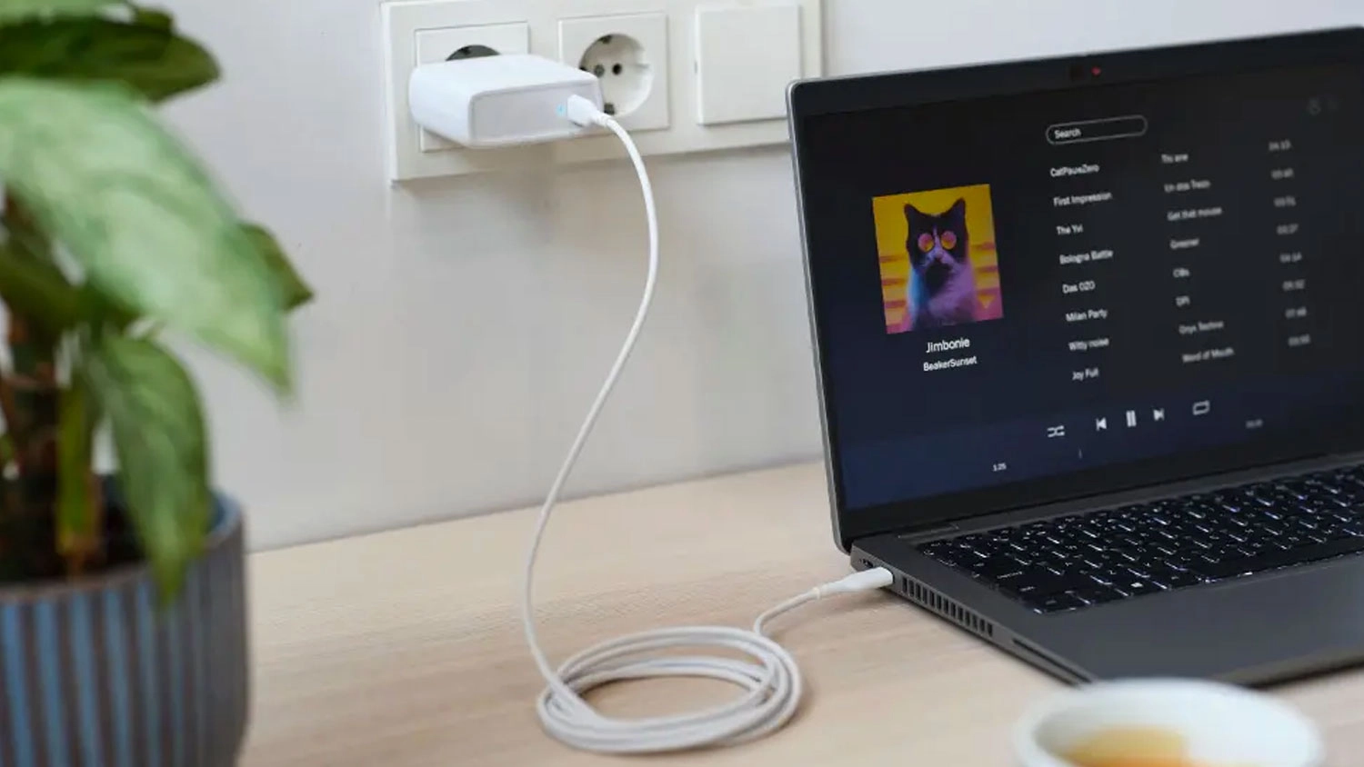 Napájací adaptér Trust Maxo USB-C 100 W White zapojený v zásuvke a notebooku
